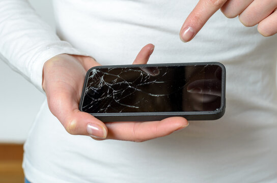 Close up of woman holding broken mobile phone