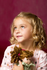 Naklejka premium Cute little girl playing with a doll.
