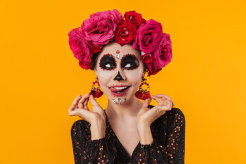 Photo of girl in halloween makeup and flower wreath showing her tongue