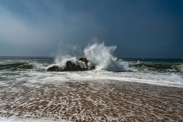 Welle im Atlantik zerbricht am Felsen.