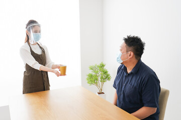 コロナウイルスの予防を徹底するカフェスタッフ