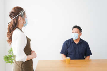 コロナウイルスの予防を徹底するカフェスタッフ