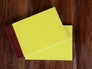 Yellow color bill books or receipt books on a wooden surface