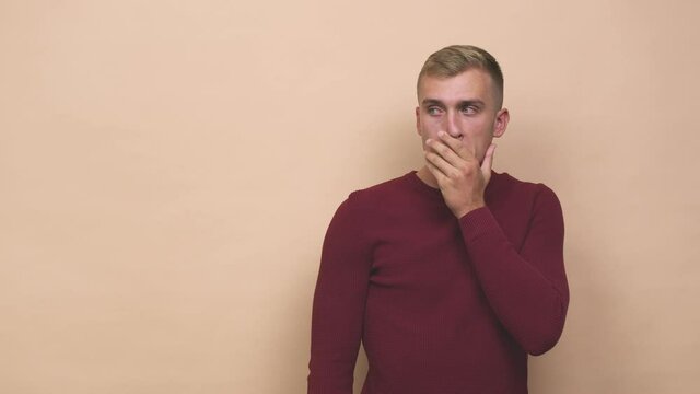 Young caucasian man thoughtful looking to a copy space covering mouth with hand