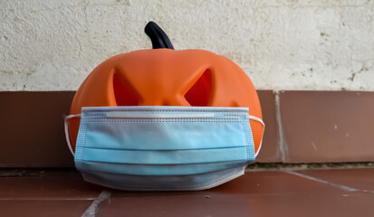 Halloween pumpkin with a protective medical mask on a white background. Halloween symbol 2020