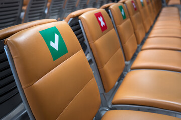 Row of leather beach chair with social distancing sign on it's backrest in public transportation...