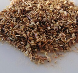 Oregano, italian natural food condiment, isolated. Dried oregano leaves on a white dish, close-up, background.