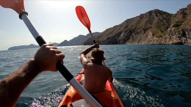 Sportsman kayaking in beautiful landscape at El Port&uacute;s, Cartagena, Spain. Kayakers in double kayak practicing sport. Aquatic sports during summer concept.
