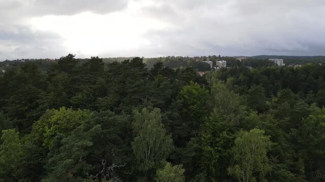 Drone shot over Borås Sweden. Crossing the freeway, trees and a lake.