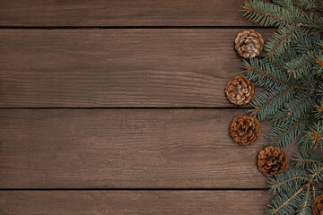 Branches of a Christmas tree and cones on a wooden table. A lot of free space, good for a banner on the site.