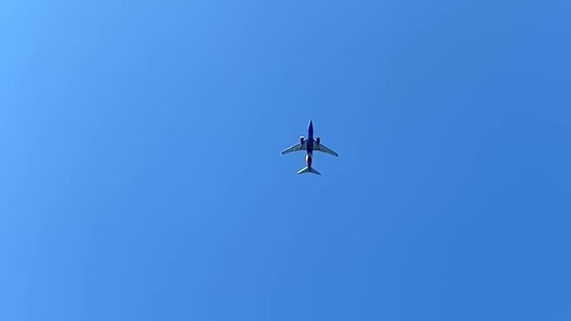 Airplane flying overhead, view beneath aircraft in sky