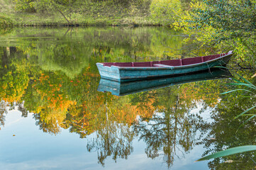 empty boat on a lake in autumn park