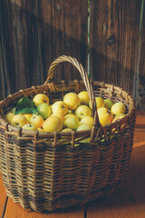 green apples in a knitted basket on a wooden background