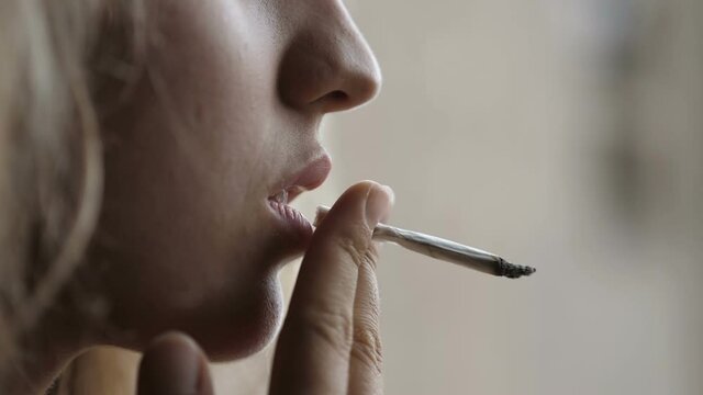 slow motion on young woman smoking a cigarette