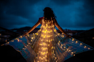 Belly dancer with light wings at night