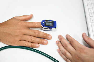 Pulse oximeter measure pulse rate and oxygen, on male finger close-up