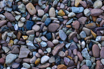 colourful stones pebbles with different sizes and shapes making texture for the background