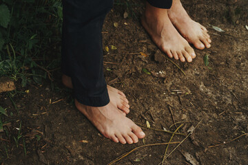 top view of bare feet standing on damp ground