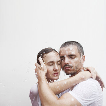 &ndash;&deg;ouple in white t-shirts under a stream of water