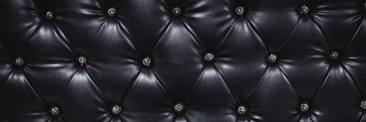 Vintage leather sofa button backrest of color black in texture. Wallpaper. for pattern and...