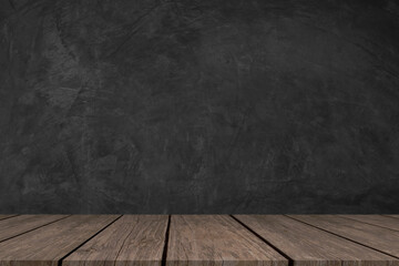Empty wooden table and dark cement wall as background.