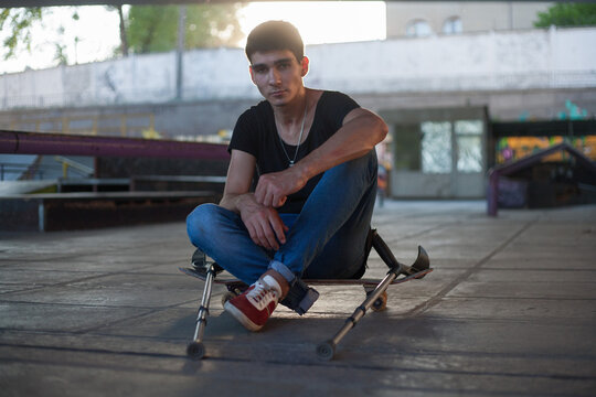 guy without legs rides a skateboard in a skate park