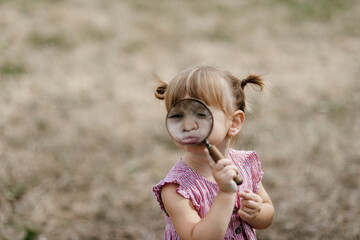 Toddler is playing with a magnifying glass and exploring