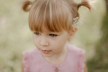 Toddler girl is playing outside on the summer day