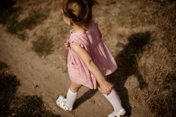 Toddler girl is playing outside on the summer day