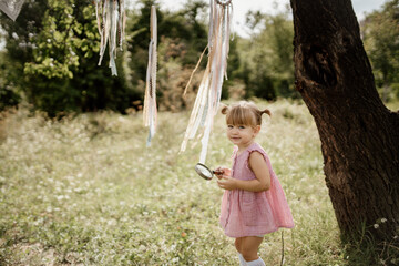 Toddler is playing with a magnifying glass and exploring