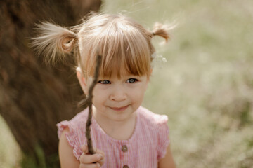 Toddler girl is playing outside on the summer day