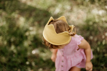 Toddler girl is playing outside on the summer day