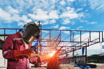 Double exposure Welding construction in red uniform, welding mask and welders leathers, a metal product is welded with a arc welding machine at the construction site
