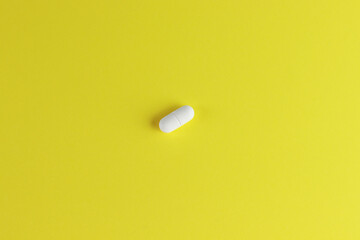 White pill isolated on yellow background  with place for text