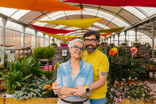 Happy mid adult couple posing in their nursery small business