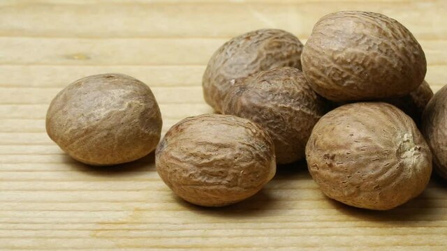 Group of raw dried whole nutmeg seeds close up