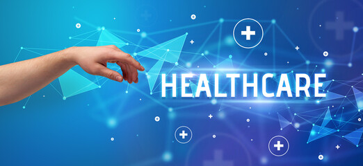 Close-Up of cropped hand pointing at HEALTHCARE inscription, medical concept