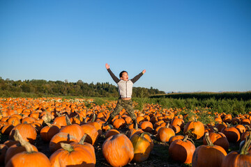 Asian Kid Jumping in Pumpkin Farm