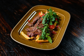 Fried meat with french fries and greens side view. Fast food with restaurant serving.