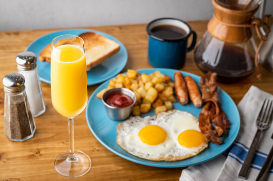 American Breakfast With Mimosa On Wooden Table Top