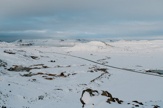 Top view of winding road and hills under snow