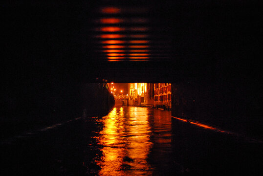Toursist trip on little boat in the canal of Amsterdam, under bridge, The Nederlands