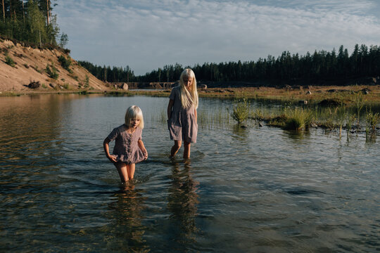 Two little sisters in the shallow water