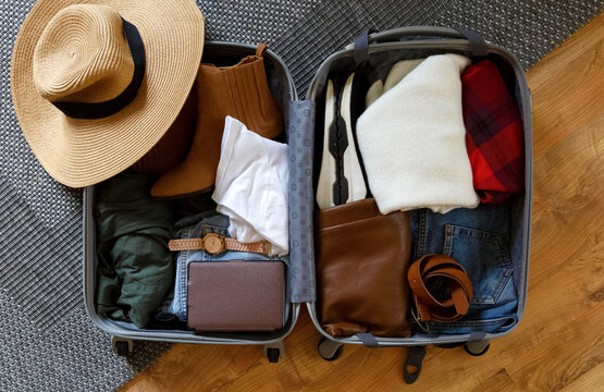 Opened packed tourist suitcase on floor