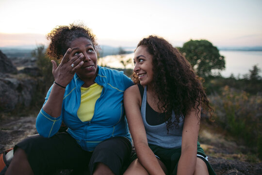 Mother and daughter hiking together at sunset.