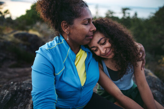 Mother and daughter hiking together at sunset.
