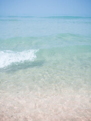 Pink sand beach with small waves and cristal water in Cadiz, Spain