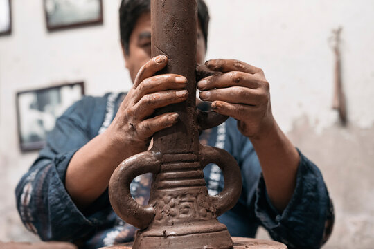 Mexican artisan sculpting with mud