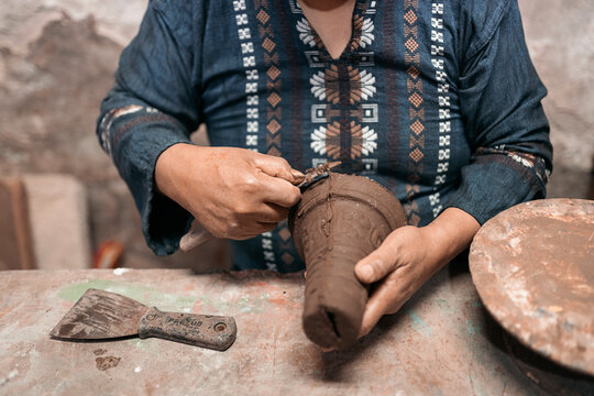 Mexican artisan sculpting with mud