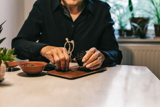 Anonymous Senior Citizen Putting CBD Cannabis in Grinder